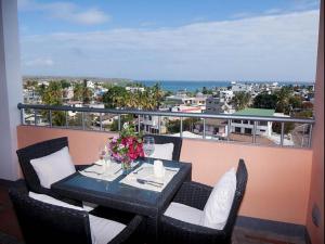 a table on a balcony with a view of the ocean at Torre Mar Galapagos Boutique Suites in Puerto Ayora