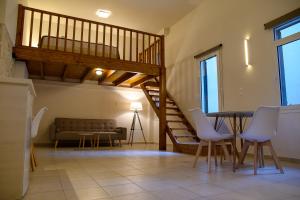 een woonkamer met een trap en een tafel en stoelen bij Uni Island - City Center Suites in Heraklion