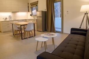 a living room with a couch and a table and a kitchen at Uni Island - City Center Suites in Heraklio Town