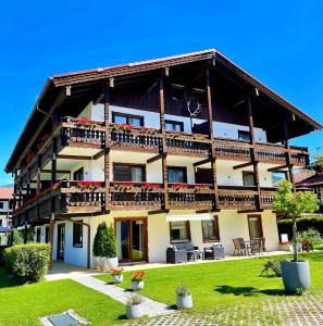 a large wooden house with balconies and a yard at Hardi's Hotel in Inzell