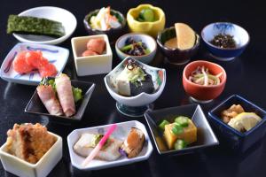 a table topped with bowls of different types of food at Muroran Prince Hotel in Muroran