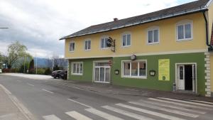 ein grünes und gelbes Gebäude an der Straßenseite in der Unterkunft sWirtshaus M&N in Zeltweg