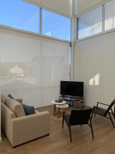 a living room with a couch and a tv at OKTHEWAY PERBES HOUSE in A Coruña