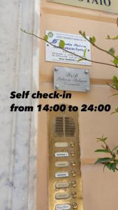 un dispositivo per il check-in automatico con un cartello sopra di Palazzo Bolasco ad Alghero