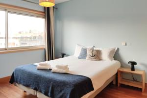 um quarto com uma cama grande e toalhas em The Refreshing Seaside Home em Matosinhos