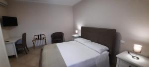 a bedroom with a white bed and a desk and a chair at Alimar Suite in Lizzano +19 photos