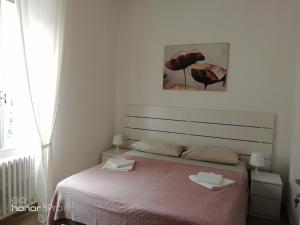 Dormitorio blanco con cama con manta rosa en Casa Viorica 2, en Ancona