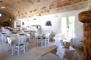 a restaurant with white tables and white chairs at Masseria Stellato in Nardò