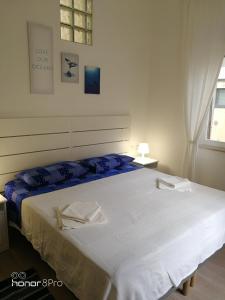 a bedroom with a large white bed with blue sheets at Casa Viorica 2 in Ancona