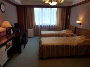 a hotel room with two beds and a window at Gagarin Hotel in Yuzhno-Sakhalinsk