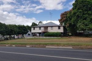 a white house on the side of a road at Golden Mount Rest Townside in Mount Morgan