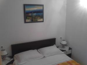 um quarto com uma cama com uma fotografia na parede em Apartments Curin em Hvar