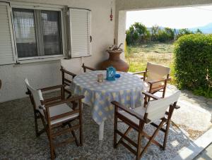a table with chairs and a blue and white table cloth at Ellina's Home - Euboea island Greece in Oxílithos