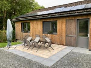 een patio met een tafel en stoelen naast een gebouw bij La Bergerie de Ster in Francorchamps