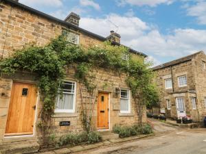 an old brick house with ivy on it at Cuckoo Cottage in Harrogate