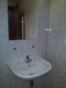 een witte wastafel in een badkamer met een spiegel bij Старият Хан-Б24 in Bansko +47 foto's