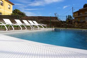 a group of chairs sitting next to a swimming pool at A Filla do Mar in Arcade