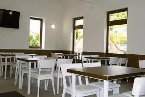 a dining room with tables and white chairs at A Filla do Mar in Arcade