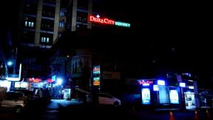 una señal de neón para una calle de ciudad oscura por la noche en Deira City Residency, en Kasaragod