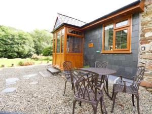 a table and chairs in front of a tiny house at Jasmine Cottage in Liskeard