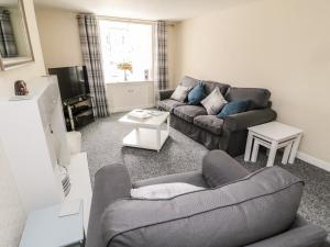 a living room with a couch and a table at Stable Lodge in Coldstream