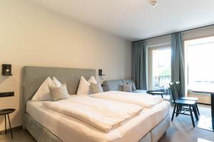 a bedroom with a large bed and a large window at Apart & Suiten Hotel WEIDEN in Schladming