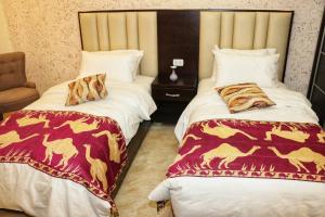a hotel room with two beds with blankets at Petra Stones Inn in Wadi Musa
