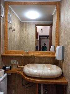 ein Badezimmer mit großem Spiegel und Waschbecken in der Unterkunft History Apartments Cetății in Sibiu + 74 Fotos