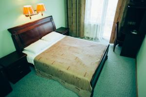 a bedroom with a large bed with a wooden headboard at Blagodat in Shaian