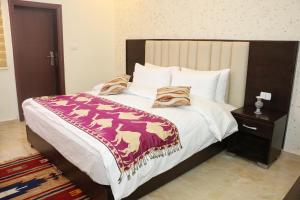 Un dormitorio con una cama con una manta de caballo. en Petra Stones Inn en Wadi Musa