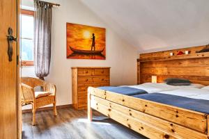 a bedroom with a large wooden bed and a chair at Apartment Fuchswald in Lackenhof