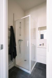 een douche met een glazen deur in de badkamer bij Smartflats - Louise Brussels in Brussel