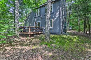 una cabaña gris en el bosque con árboles en 6 Mi to Lake Harmony Quiet Getaway with Deck!, en Lake Harmony