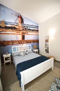 a bedroom with a bed and a mural of a windmill at Dimora Mothia in Marsala