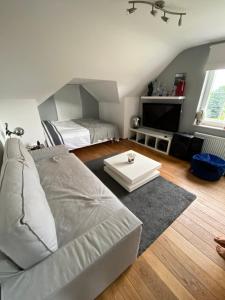 a living room with a couch and a bed at BB La Marinière in Theux