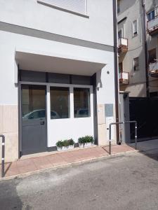 um edifício branco com uma porta e algumas plantas em ART DECO city center near the beach! em Terracina