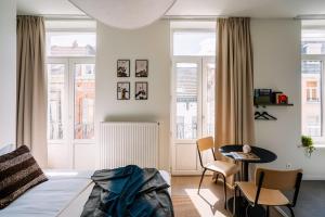 - une chambre avec un lit, une table et des chaises dans l'établissement Smartflats - Louise Brussels, à Bruxelles