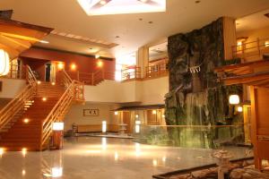 a large lobby with a large rock wall at Hotel Towadaso in Towada