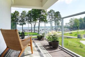 een balkon met een stoel en uitzicht op het water bij Good Morning Sunshine - Nautica Resort Apartment in Giżycko