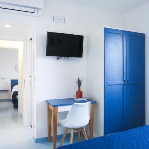 - une chambre avec un bureau bleu et une chaise blanche dans l'établissement Lena Magda B&B, à Furore