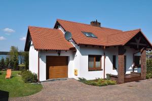 Casa blanca con techo rojo y entrada en Dom U Zbyszka z prywatną plażą en Kiedrowice