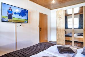 - une chambre avec un lit et une télévision murale dans l'établissement Ferienwohnung Bergerlebnis Ötscher, à Lackenhof