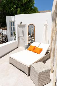 a bed on the back of a patio at The Museum Project Oia in Oia