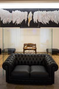 a black leather couch in a room with a table at B&B Costa Masciarelli - Suite affrescate a due passi dal Duomo in LʼAquila +30 photos