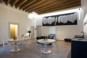 a living room with two tables and chairs and a chandelier at B&B Costa Masciarelli - Suite affrescate a due passi dal Duomo in LʼAquila