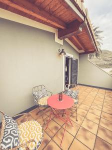 a patio with a red table and chairs on a porch at La Casa DelBelga in Muskiz