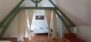 ein Schlafzimmer mit einem Bett im Dachgeschoss in der Unterkunft La maison d'amis du moulin in La Chapelle-Viel