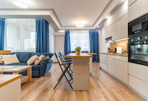 a kitchen and living room with a couch and a table at WrocApartments StarCenter - Parking Free in Wrocław