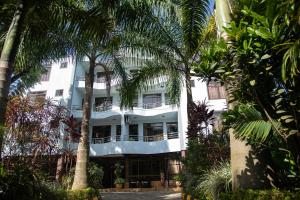 a building with palm trees in front of it at Panama Garden Resort in Moshi