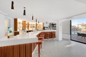a kitchen with a bar with brown stools at Hotel Principe Wellness&Spa in Playa de Palma